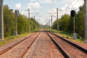 Fototapeta na wymiar railroad tracks with red stones and semaphore in summer in Europe