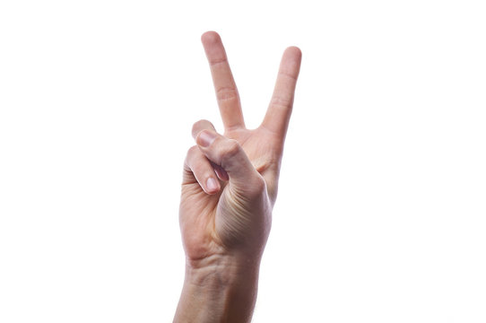 The man raised two fingers up. 2 thumbs up is a symbol of victory. Uncultured British gesture. V means vendetta. A man's hand on a white background in a photo studio shows a symbol.