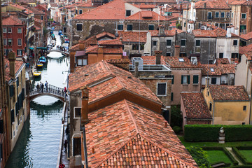 Venetian narrow channel and red clay tile roofs. An aerial top-view