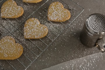 Raw heart shape cookies with sugar icing on baking tray