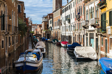 A narrow canal with boats in Venice, Italy