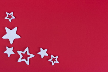 White five-pointed wooden stars on red cardboard.