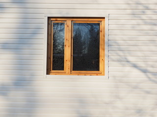 wooden window on white siding background