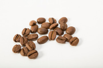 macro image of dark aromatic coffee beans  on   white background with  copy space.