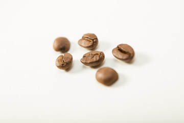 macro image of dark aromatic coffee beans  on   white background with  copy space.shallow depth of field.