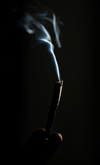 Rolling cigarette and smoke on black background