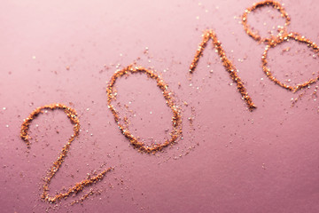 2018 made of rose gold glitter on purple background