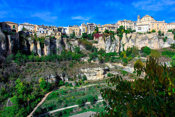 Bright colorful picture of old Historic hanging houses in the valley in Cuenca, Spain. Tree on the foreground