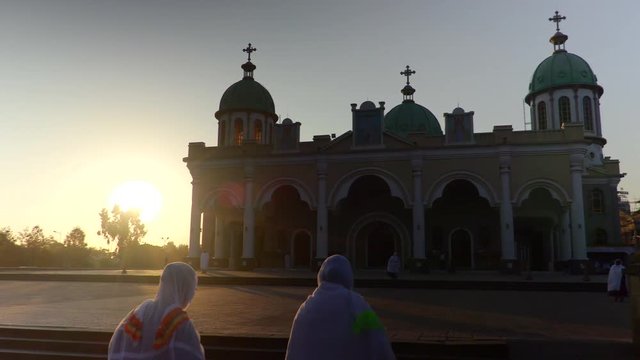 A smooth gimbal shot following local women enter the Bole Medhane Alem Cathedral, Addis Ababa, Ethiopia