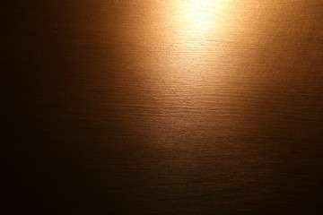 Golden abstract painting. Light in dark background. Golden acrylic paint brushed texture.