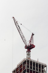 Fototapeta premium A crane sits on top of a building being constructed in central manhattan.