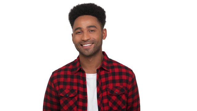 portrait of happy glad dark-skinned guy in red plaid shirt looking on camera smiling broadly with white teeth over white background. Concept of emotions