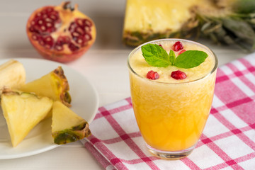 Fresh pineapple smoothie with pomegranate seeds.