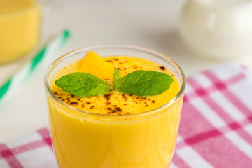 Fresh mango smoothie with milk, cinnamon and mint.