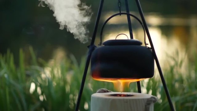 Boiling kettle on the fire outdoor slow motion