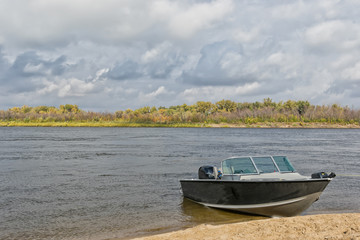 Aluminum motor boat moored in sandy shore rapid river