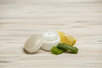 Capacity for cosmetic products
moisturizer for face care
anti-aging skin care
cream jar and aloe leaf
 white plastic cream jar with chamomile petals
cream from wrinkles
skin care product