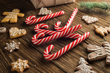 Chrismas cookies, candy canes on wooden background. Holiday mood. Top view.