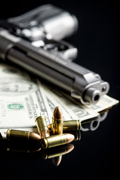 9 mm bullets, dollars and handgun.