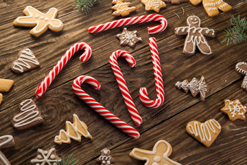 Chrismas cookies, candy canes on wooden background. Holiday mood. Top view.
