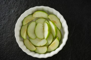Slice of green apple on bowl - Powered by Adobe