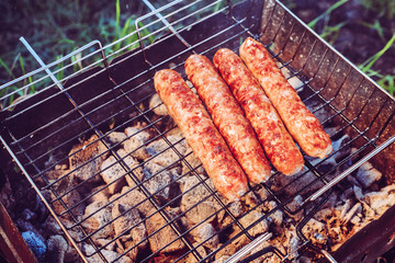 Grilling sausages on BBQ. Juicy beef. camping