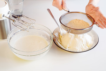 Making dough by female hands on white table