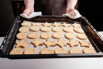 the process of making christmas cookies, raw dough, rolling pin and baking star forms.