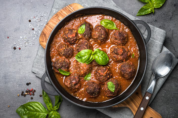 Meatballs in tomato sauce on a black background.