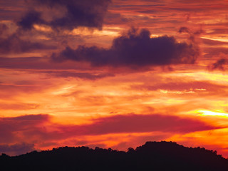 Twilight beautiful evening cloudy sky  after sunset background . There are silhouette mountains and trees.