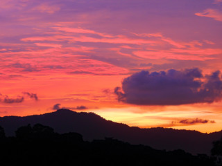 Twilight beautiful evening cloudy sky  after sunset background . There are silhouette mountains and trees.