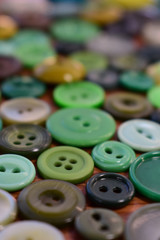 green sewing buttons on a wood table