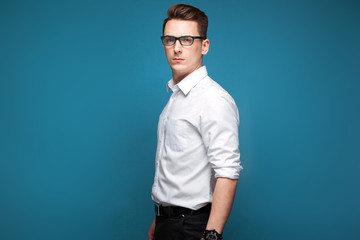 Obraz premium Young attractive businessman in costly watch, black glasses and white shirt