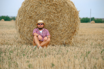 Naklejka na ściany i meble man resting after hay in haystacks