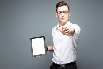 Young attractive businessman in costly watch, black glasses and white shirt hold empty tablet