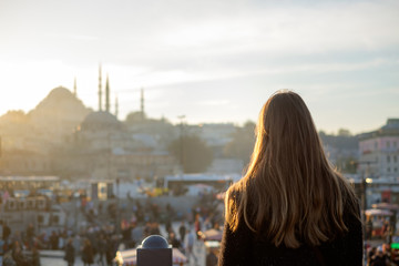 Fototapeta na wymiar Young girl looks at traveling Mosque in Istanbul