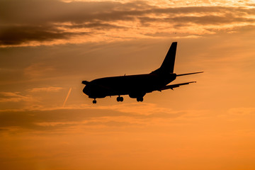 Obraz na płótnie Canvas Airplane landing at sunset
