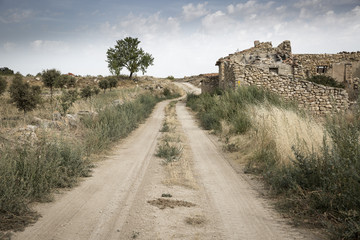 a dirt road and ruins of abandoned rustic houses next to Borja, province of Zaragoza, Spain