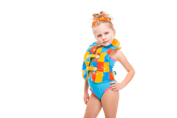 Fototapeta na wymiar Beautiful little girl in in blue swimming suit and colorful life jacket