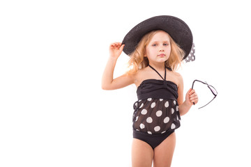 Beauty cute little girl in in black swimwear and black hat hold glasses