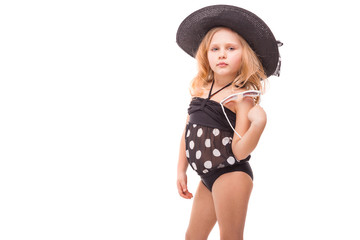 Attractive cute little girl in in black swimwear and black hat hold glasses