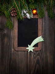 Vintage empty chalkboard with fir Christmas tree and wood modern decor on wooden background