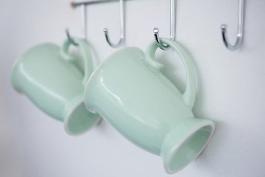 Close-up of mugs hanging on hook