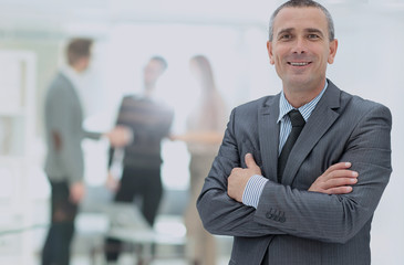 Happy mature business man looking at camera with satisfaction at office