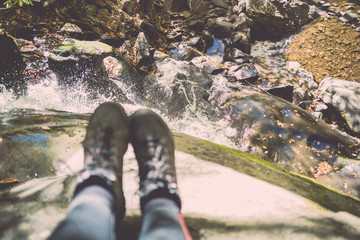 Woman's hiking boots hanging over edge of cliff near Laural Falls in Smoky Mountains National Park