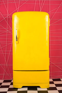 Naklejki old vintage yellow refrigerator on a pink background
