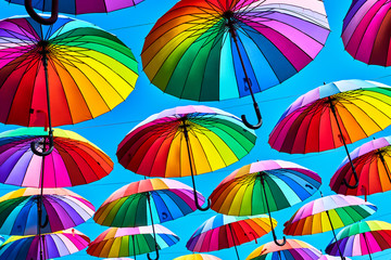 Rainbow umbrella on sky background. Many colorful umbrellas. umbrella street decoration