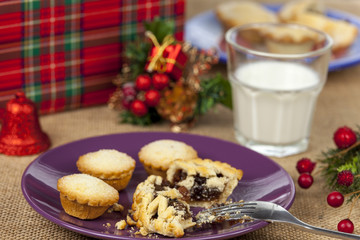 Broken mince pie and milk on a christmas table