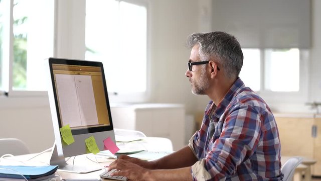 Web designer working in office on desktop computer