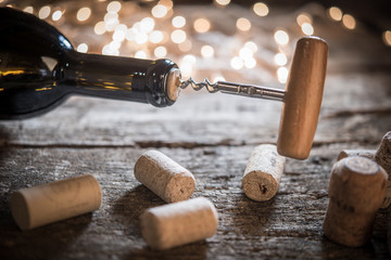 Wine bottle opening on glitter  holiday lights in background